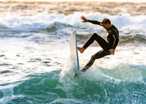 A man riding a surfboard on the beach in San Diego