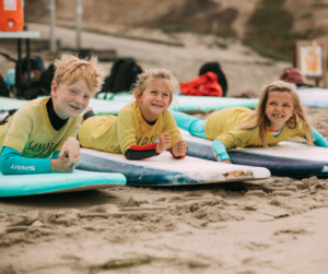 Kids lying on surfing board at San Diego Surf School 