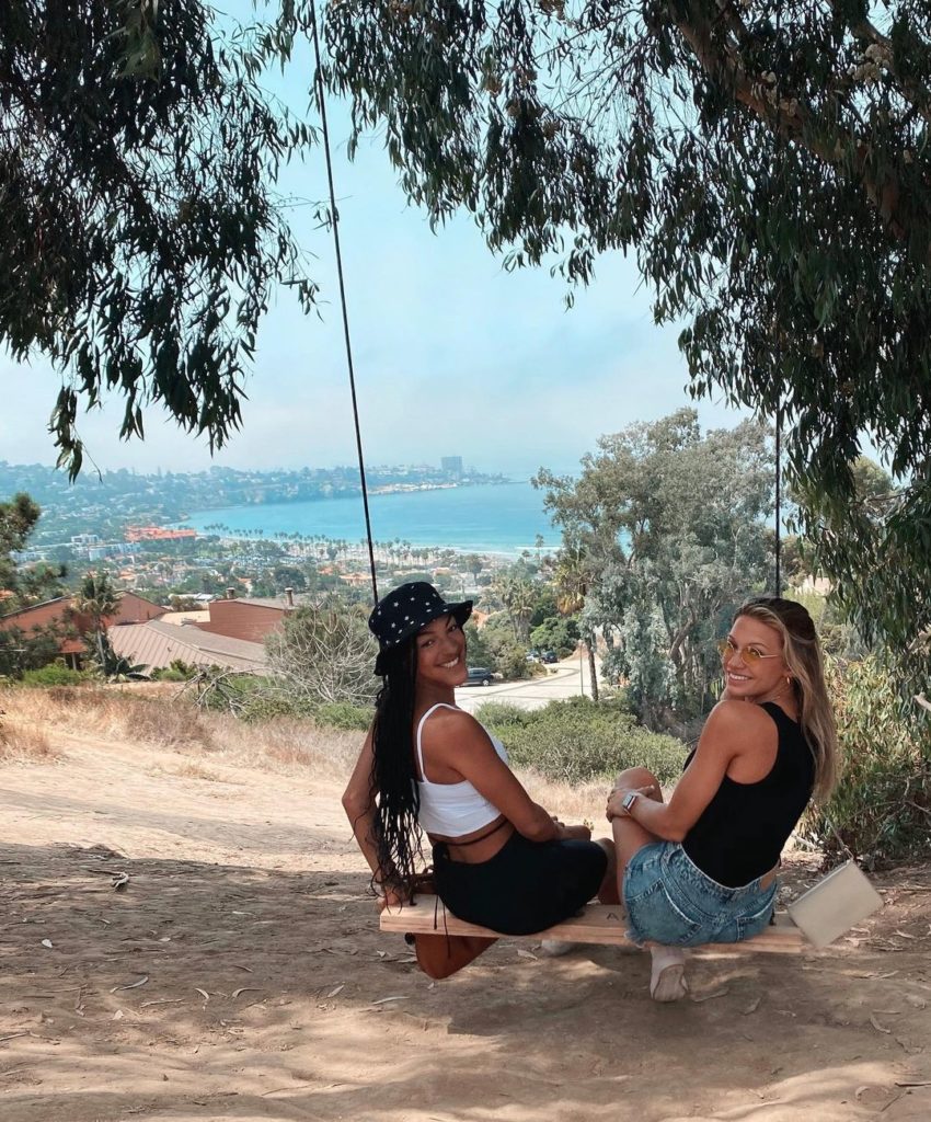 two girls on hidden swings overlooking ocean