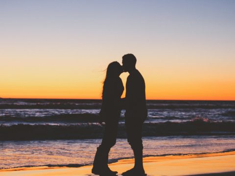 couple kissing onbeach at sunset