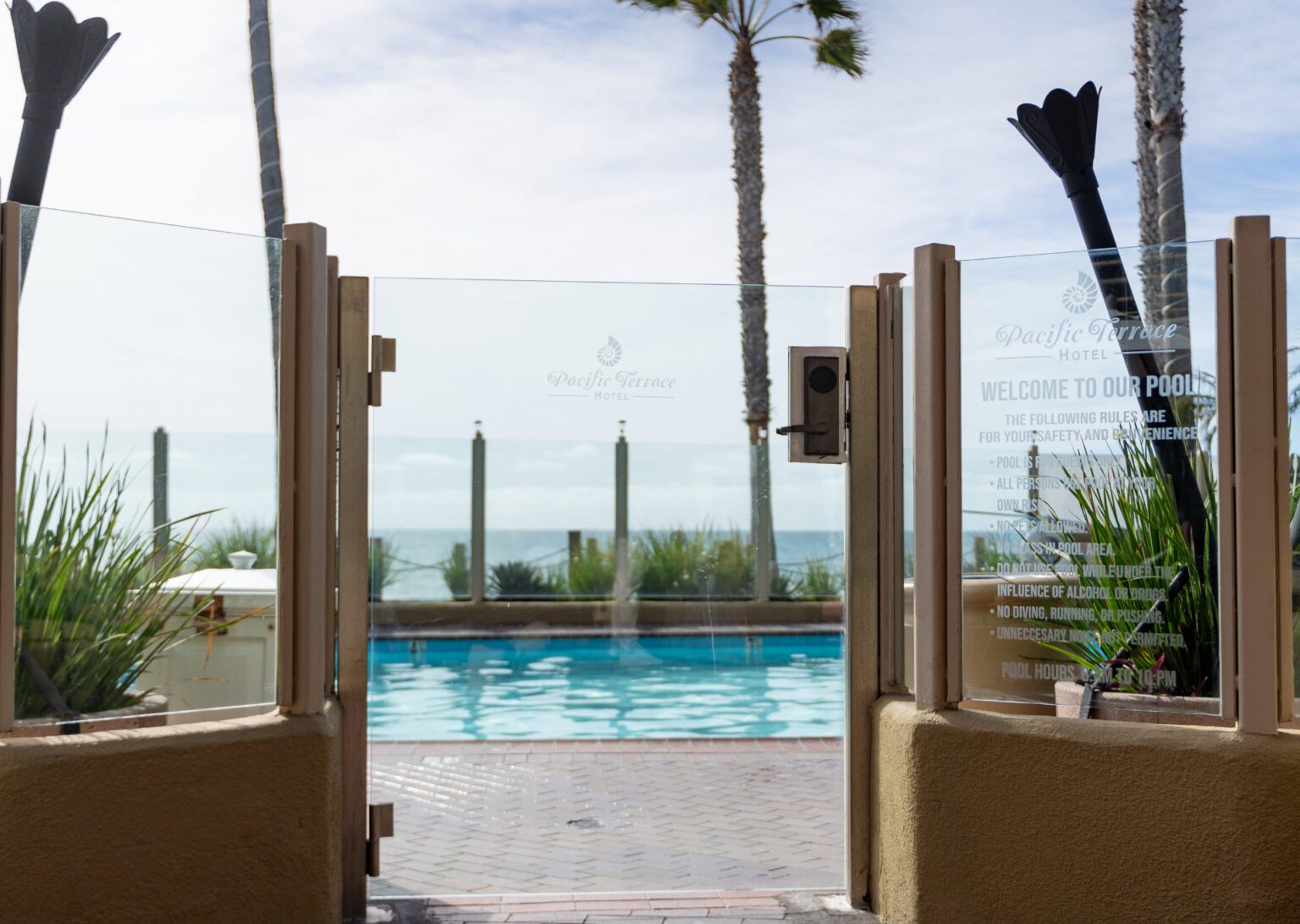 Elevated pool area with glass sidings and view of the beach