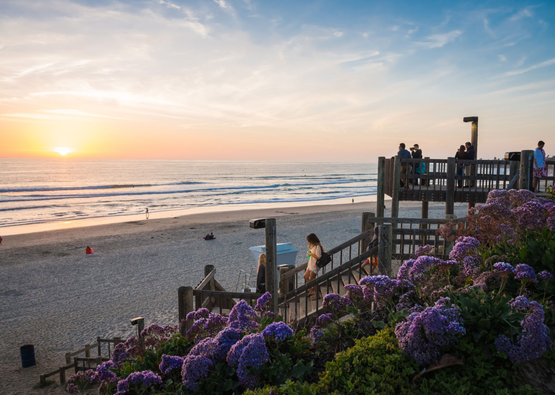 Beach stairs going down to access beach with a sunset view