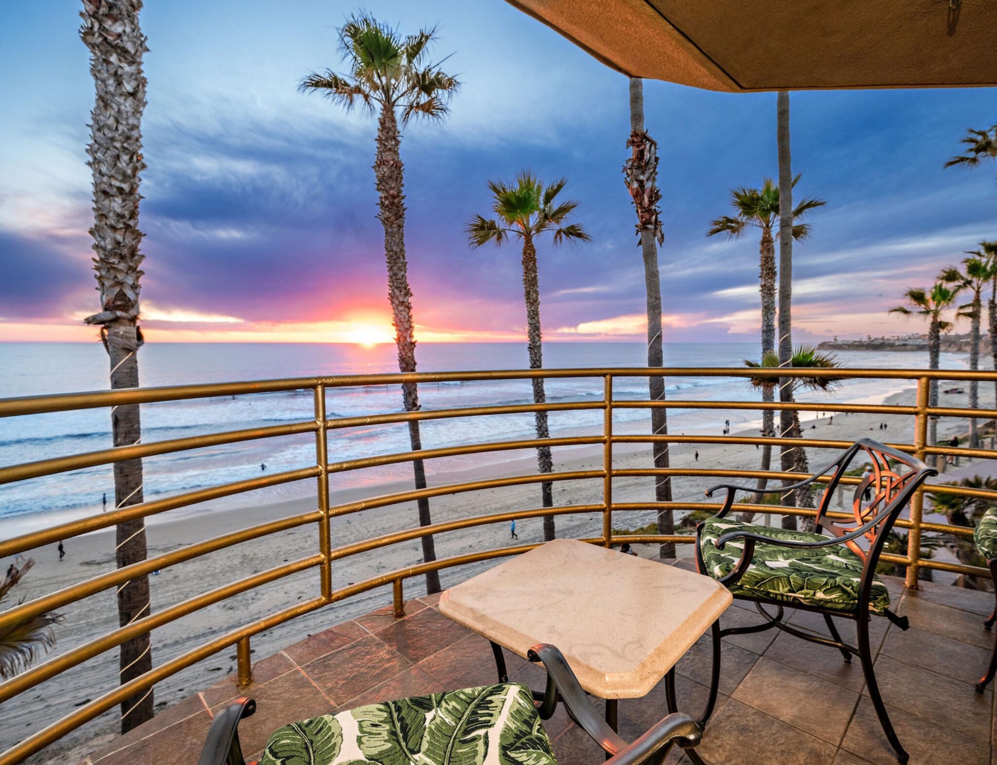 Side view photo of Balcony with a view of tall trees, pool, and pacific beach