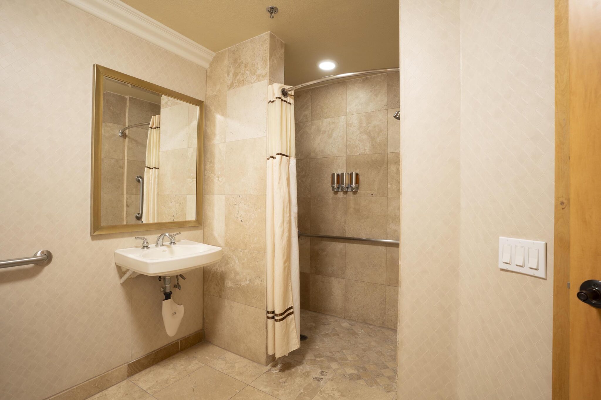 Accessible bathroom with curtain shower and bathroom amenities
