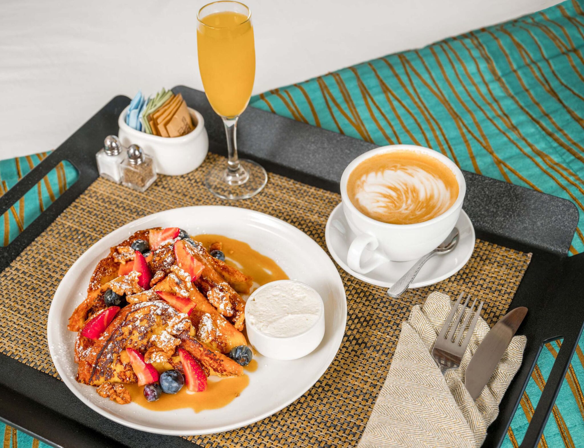 Breakfast in bed with french toast, juice, and coffee