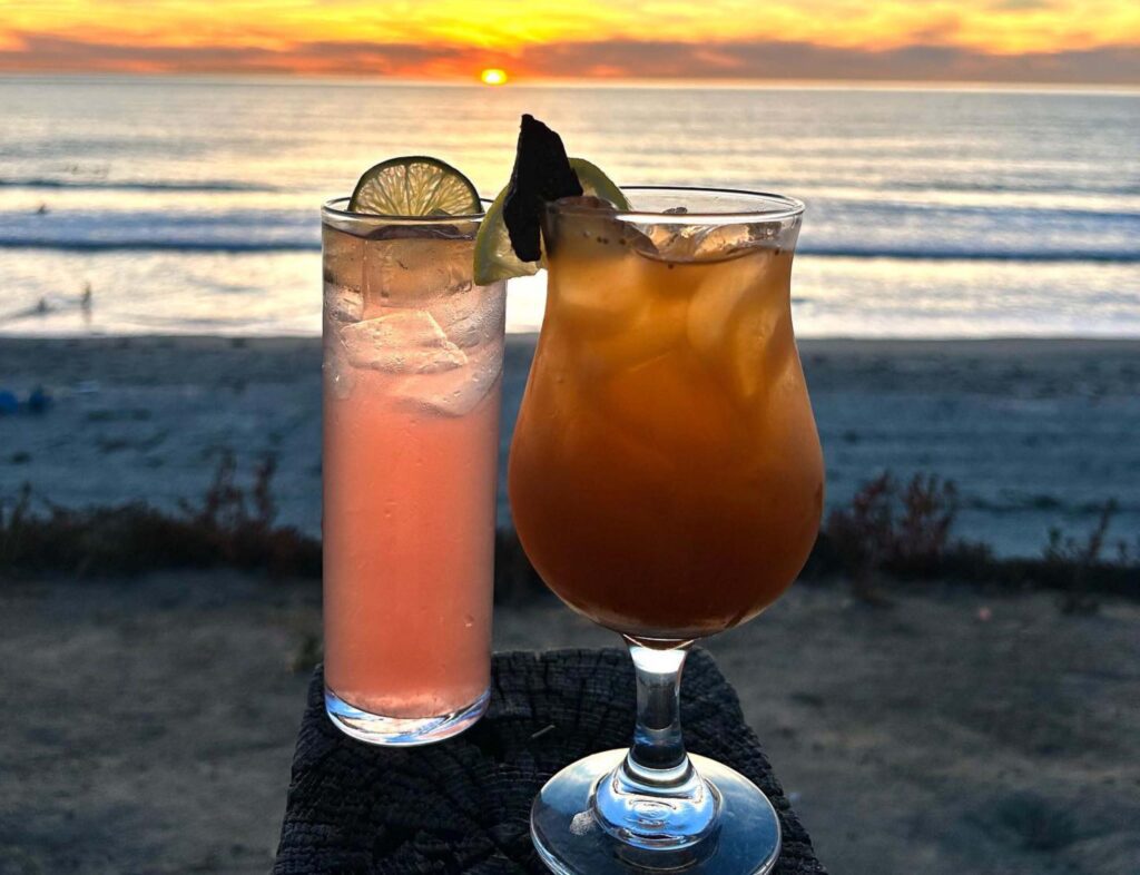 Two cocktails drinks with a sunset view background
