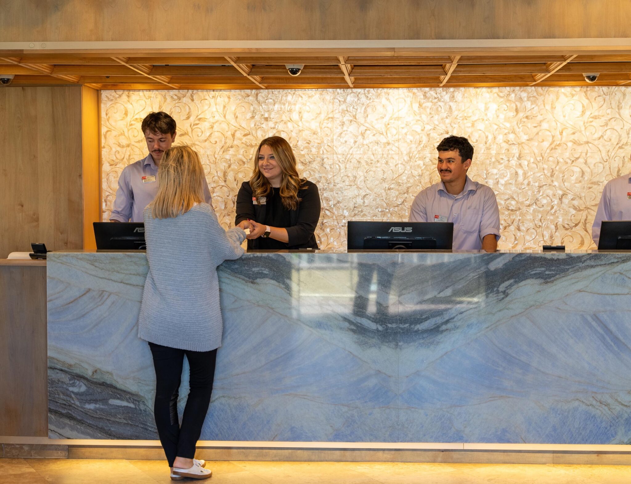 Hotel front desk interacting with a guest