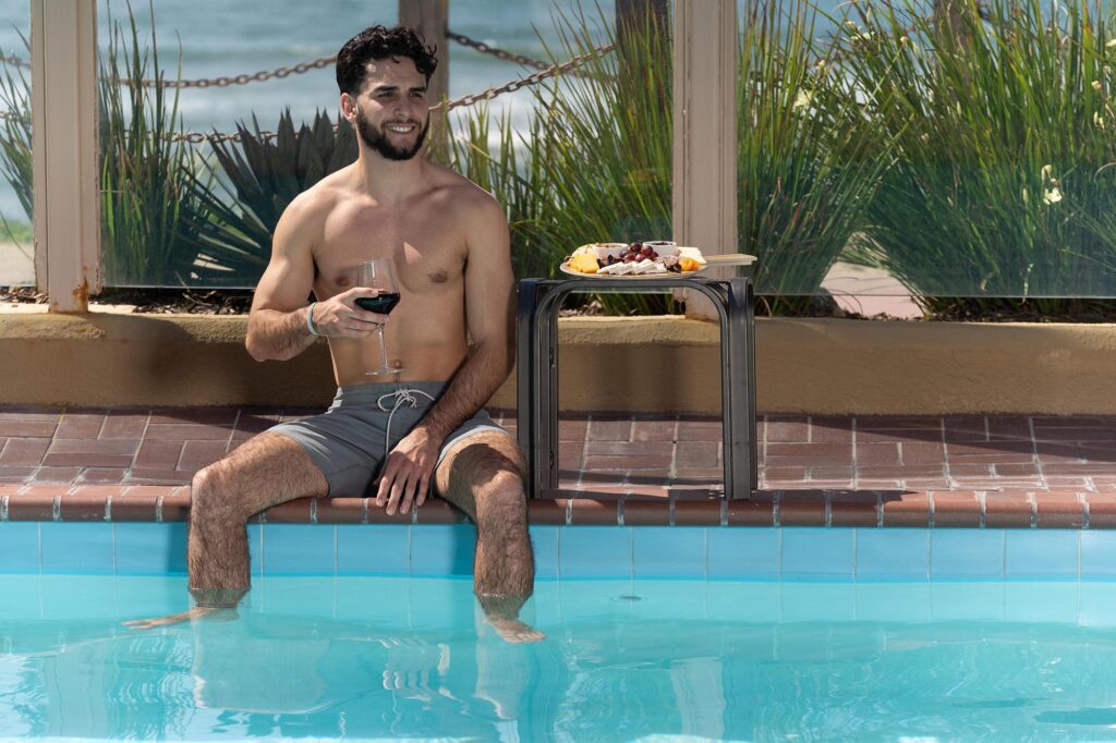 Man enjoying some wine while dipping in a pool