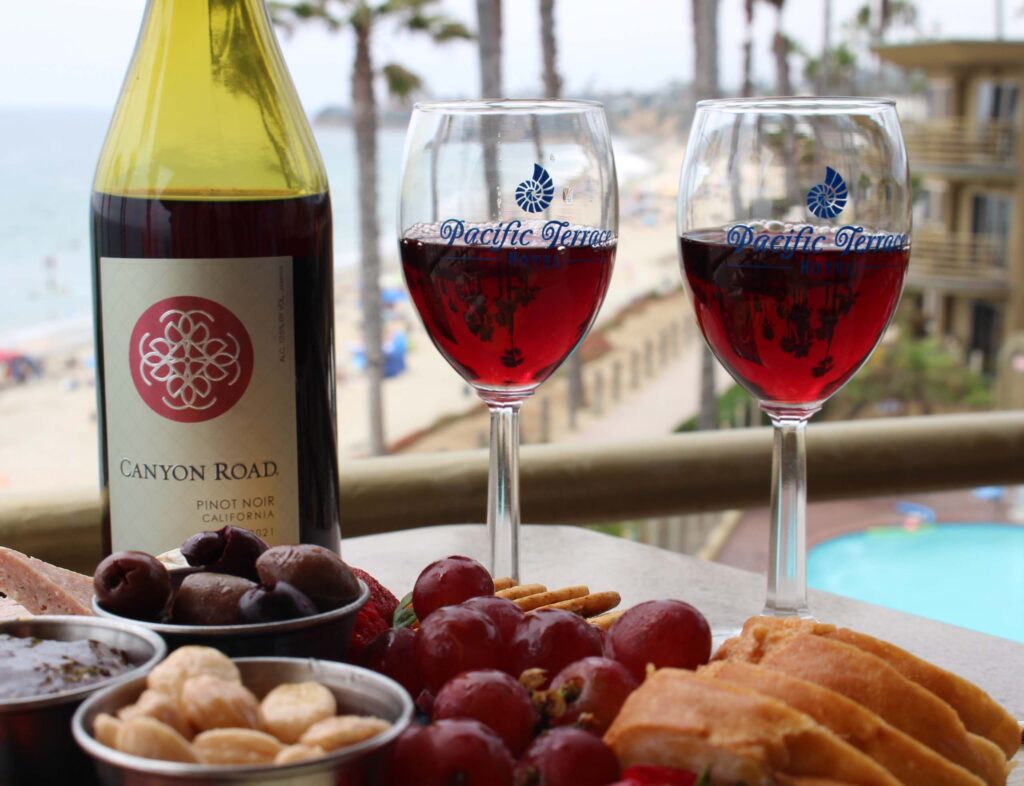Two wine glasses, a bottle, and charcuterie
