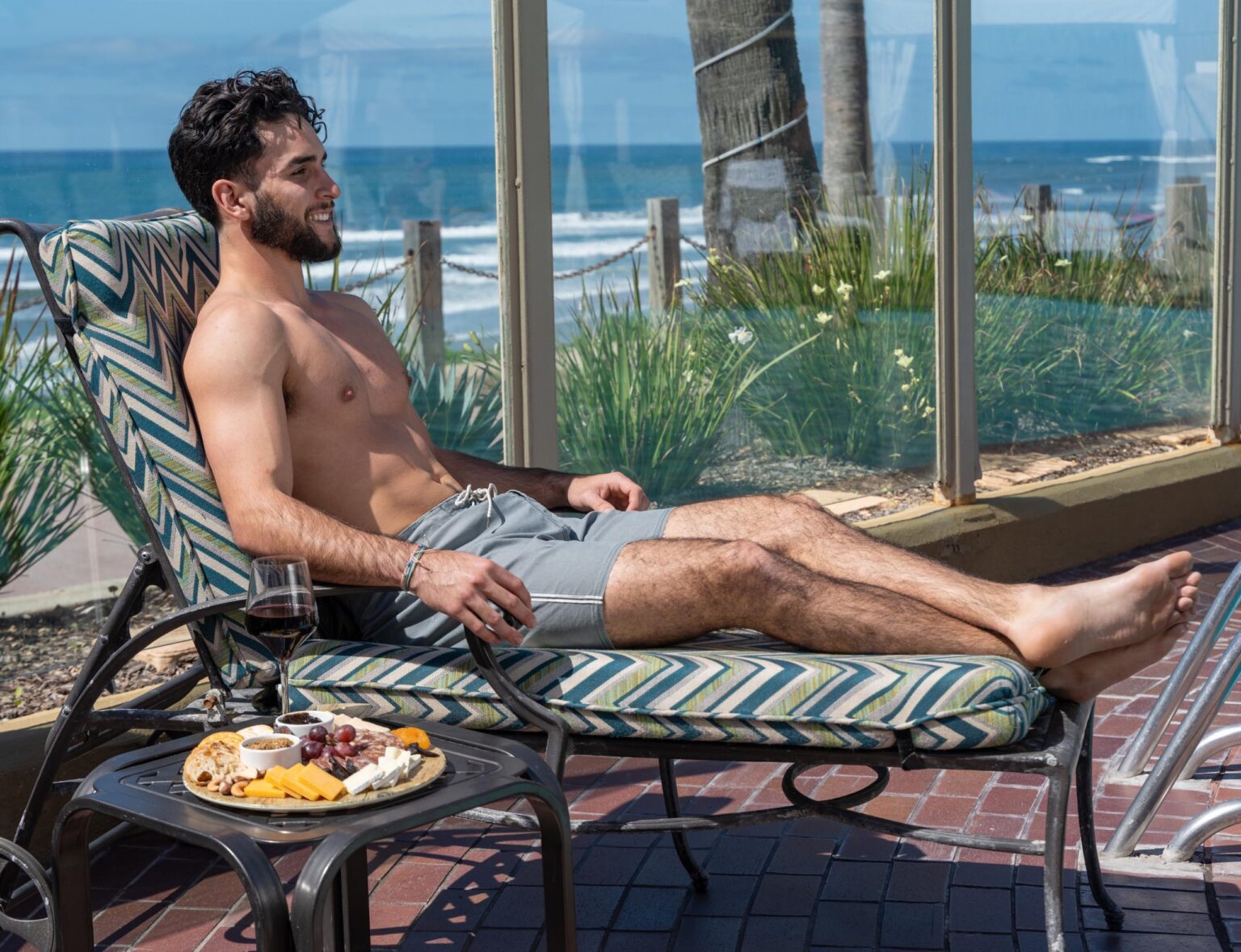 Man smiling while seating in a pool bench