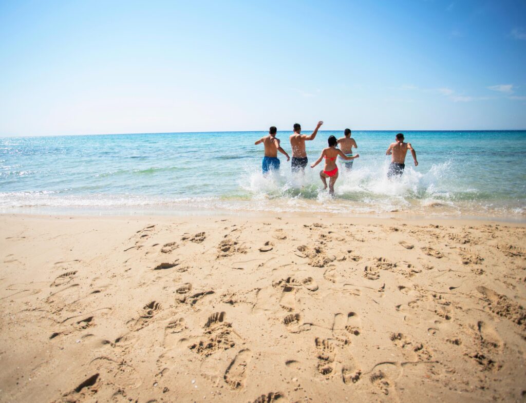 5 people running towards the beach