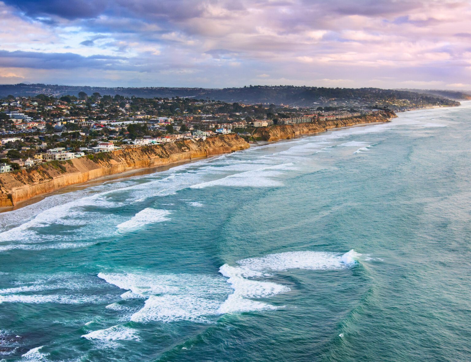 Aerial view of the ocean, beachline, and Pacific Beach