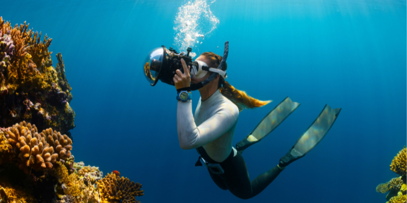 woman taking a photo while scuba diving