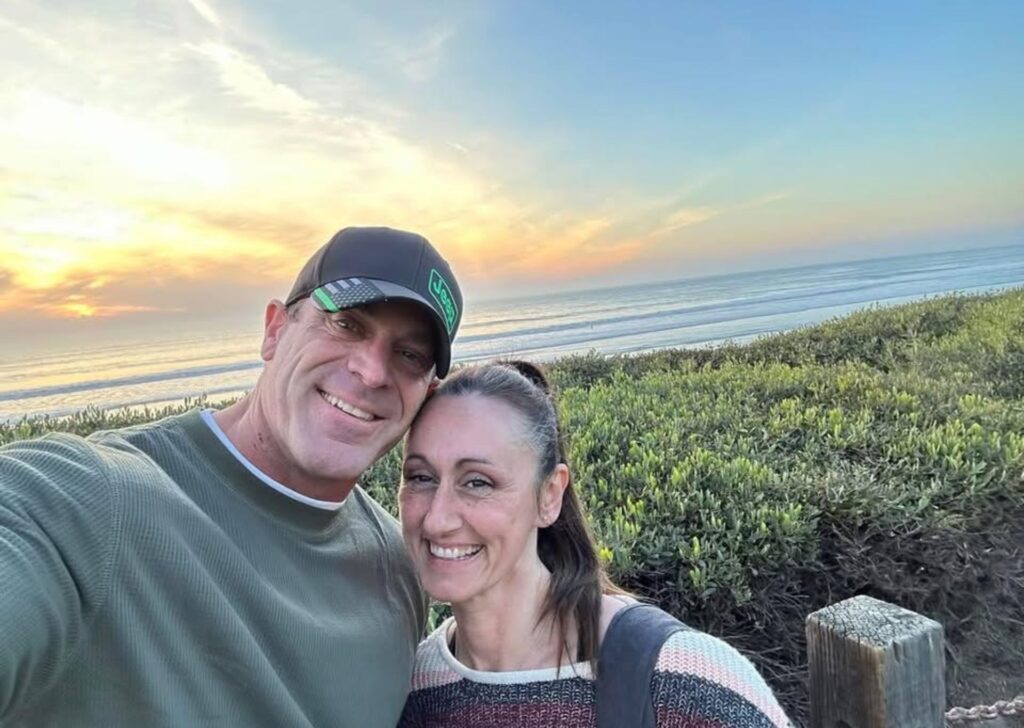 A couple takes a selfie at sunset at the beach