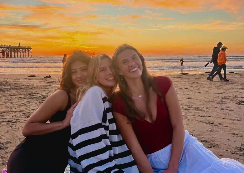 Three women at the beach at sunset