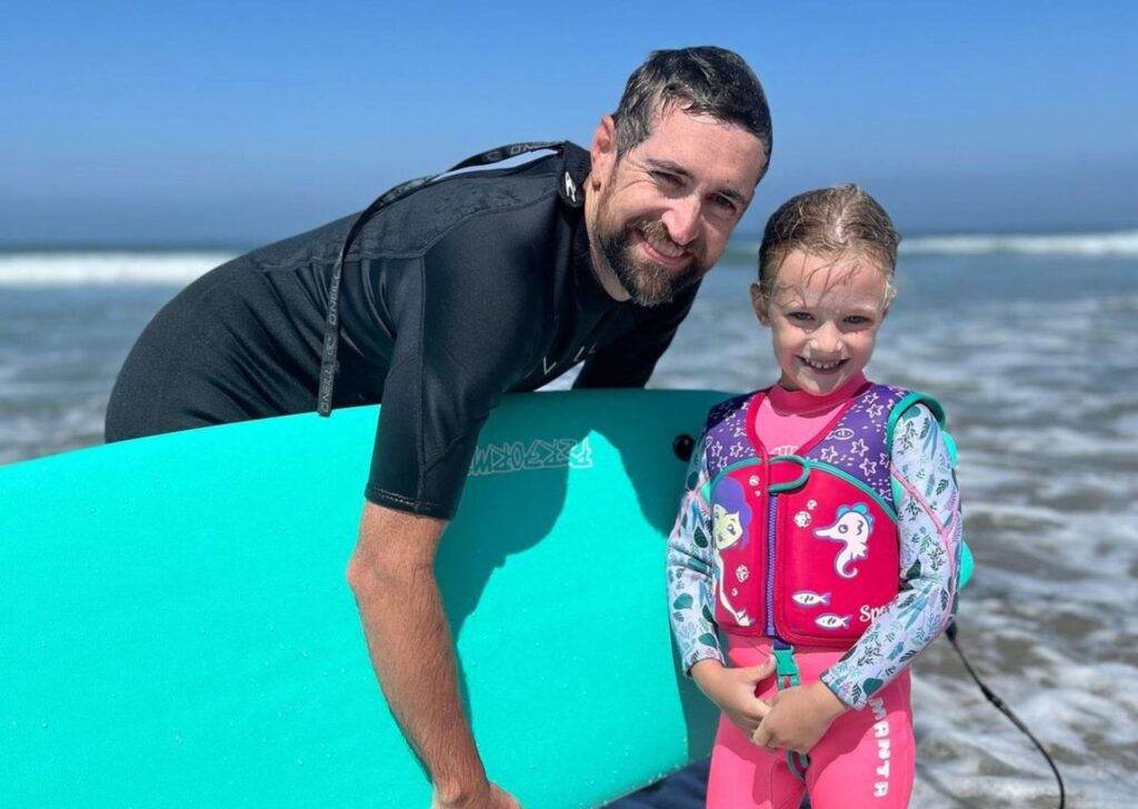 a young child with a surfing instructor