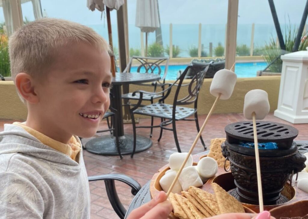 a child making s'mores by the pool