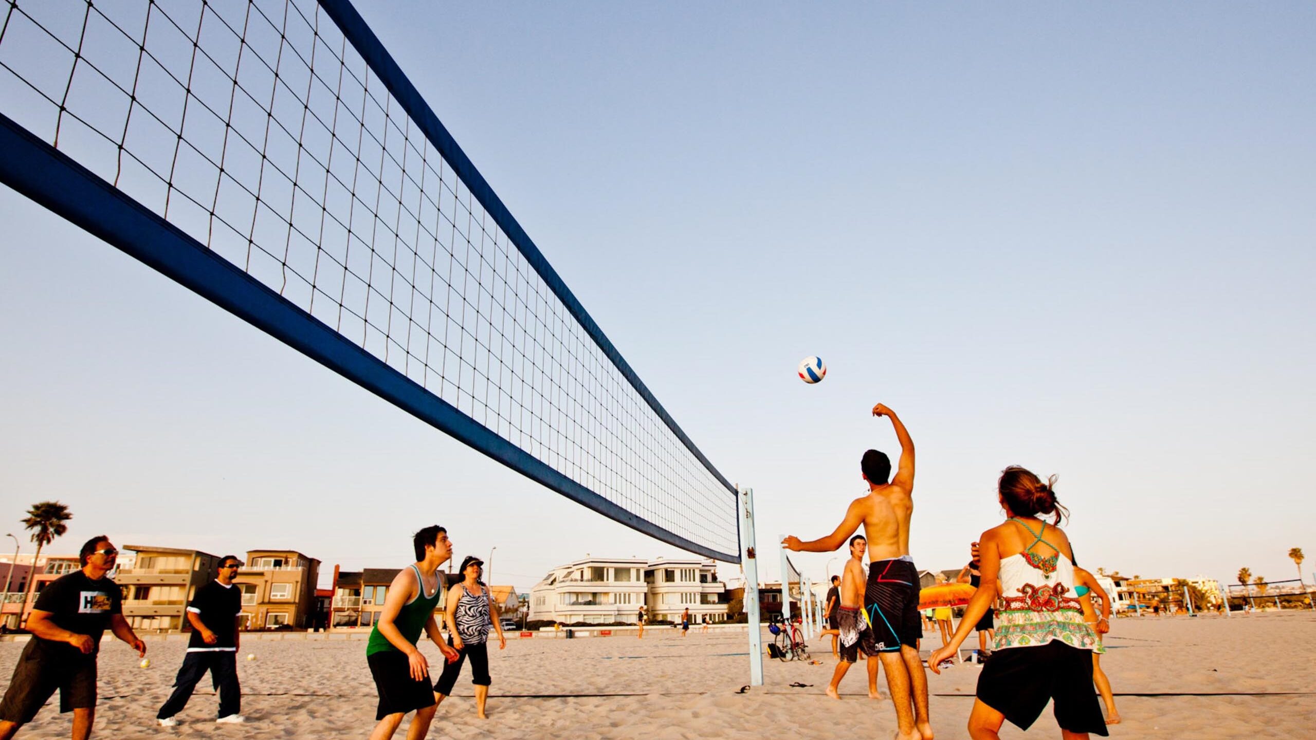 People playing volleyball on the beach.