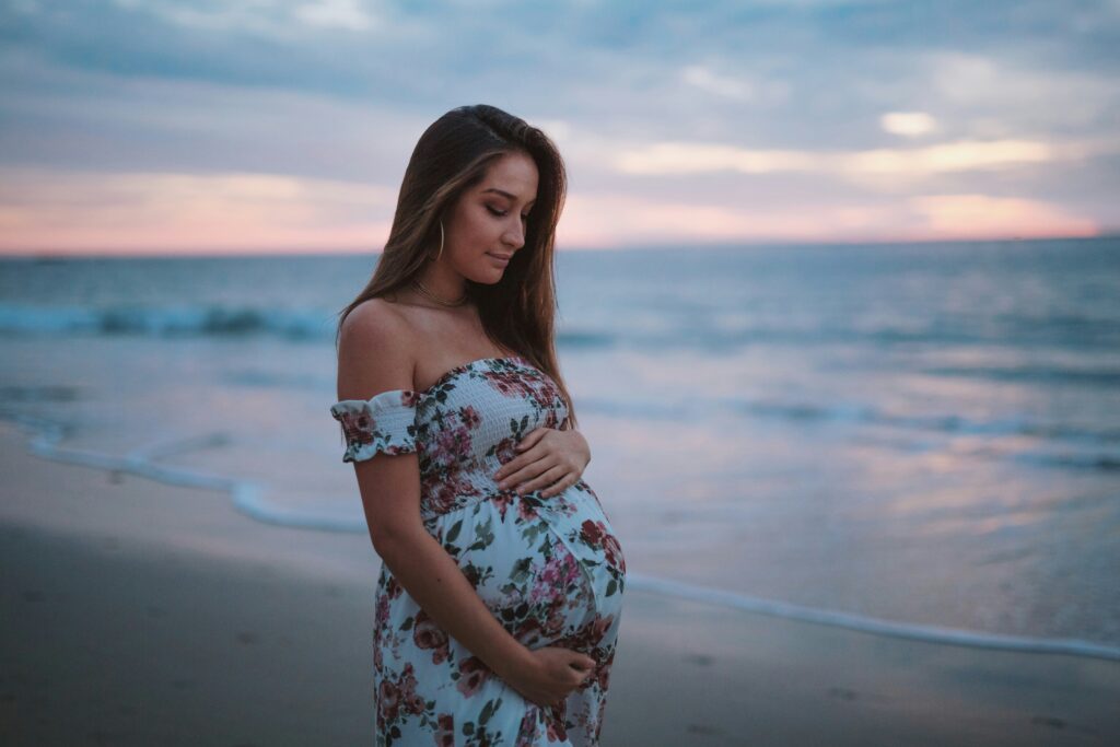 pregnant woman on beach at sunset