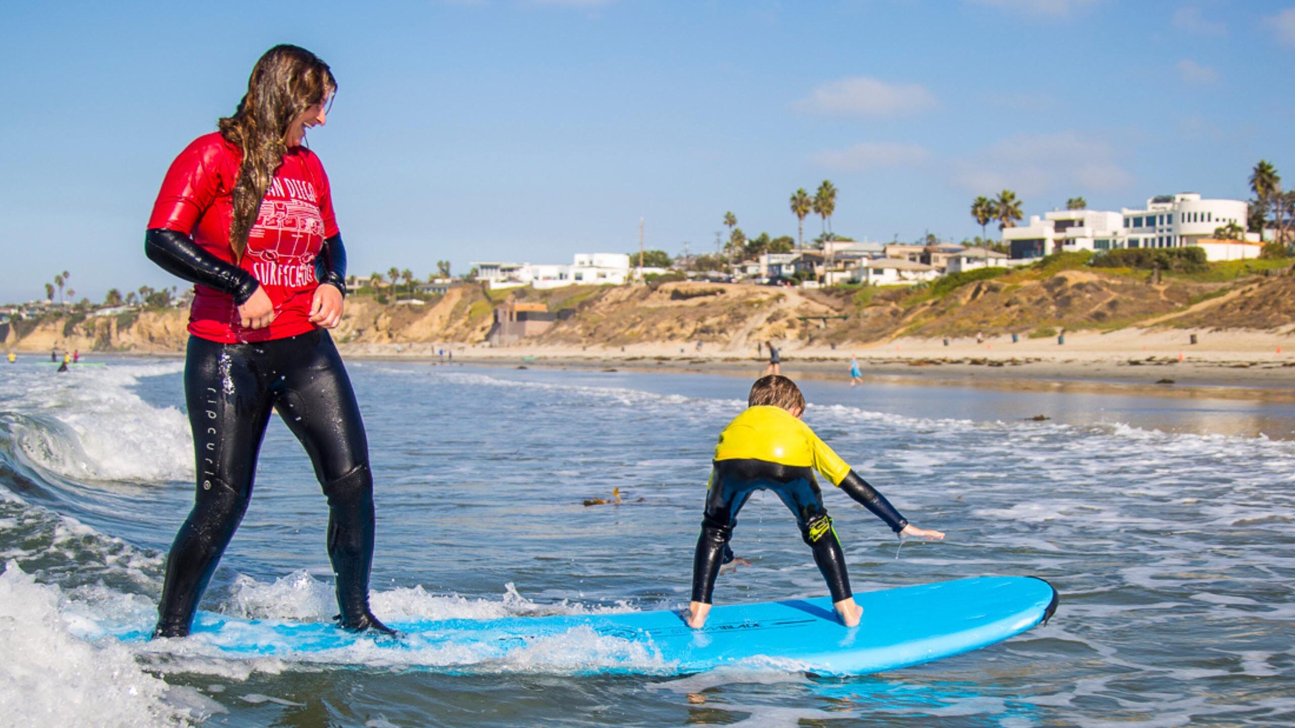 Surfer teaching a kid to surf